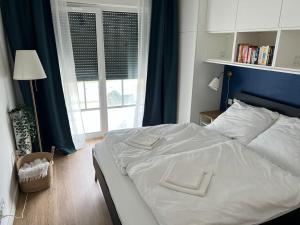 a bedroom with a white bed and a window at Baltic Nest - Dziwnów in Dziwnów