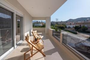 a balcony with two chairs and a view at Villenia Luxury Apartments in Kissamos