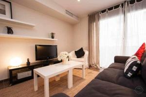 a living room with a couch and a tv at Port VII Apt centrico acogedor w balcon 23 in Barcelona