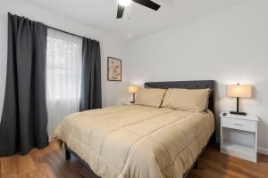 1 dormitorio con 1 cama y ventana con ventilador de techo en Gainesville-newly remodeled home, en Gainesville