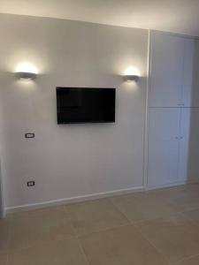 a living room with a tv on a white wall at Oleander Apartment in Castellammare di Stabia