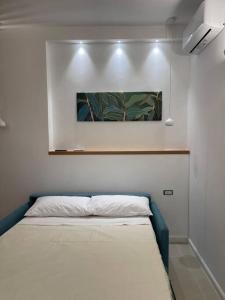 a bed in a room with a painting on the wall at Oleander Apartment in Castellammare di Stabia