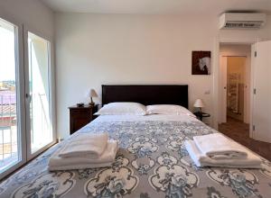 een slaapkamer met een groot bed en handdoeken bij Locanda Castellini-private parking in Siena