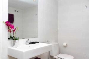 a bathroom with a sink and a toilet and a mirror at Port III Apart céntrico ideal familias 11 in Barcelona