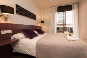 a bedroom with a large bed with a window at Port IV Apart céntrico ideal grupos 12 in Barcelona