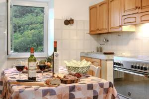 una mesa con 2 botellas de vino y copas de vino en La casa di Leo, en Riccò del Golfo di Spezia