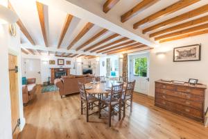 a kitchen and living room with a table and chairs at Smithy Cottage Coniston in Coniston
