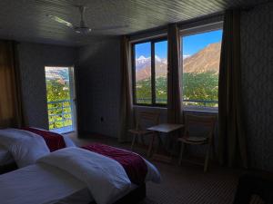 Habitación de hotel con 2 camas y ventana grande. en Hunza Bliss Hotel, en Alīābād