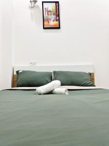 een bed met twee witte kussens erop bij Pema House Hotel in Da Thanh