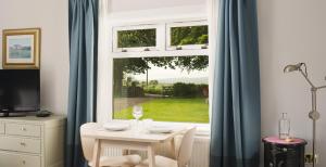 a table and chairs in front of a window at Stylish self contained studio near Glasgow Airport in Lochwinnoch