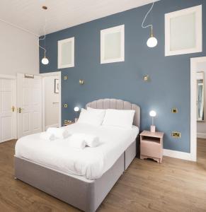 una camera con un grande letto con una parete blu di Stylish self contained studio near Glasgow Airport a Lochwinnoch