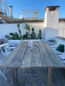 une table en bois devant un mur avec du cactus dans l'établissement Casa Annina, à Gallipoli