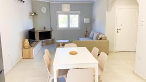 a living room with a white table and chairs at Zoe in Nea Kallikrateia