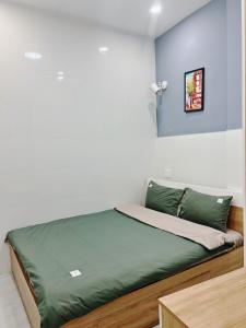 een bed in een kamer met een blauwe en witte muur bij Pema House Hotel in Da Thanh