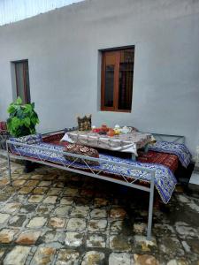 a bed in a room next to a building at LION Guest House in Bukhara