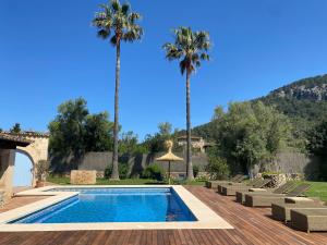 a swimming pool with palm trees in a yard at Villa Alyvos Pollensa - BY EMERALD STAY in Pollença