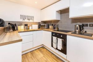 uma cozinha com armários brancos e pisos em madeira em Modern 2 bedroom Flat in Montrose em Montrose