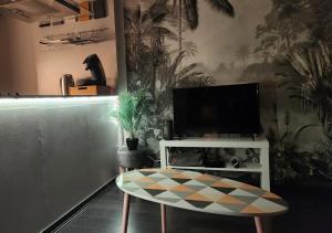 a living room with a tv and a table and a table sidx sidx at 'Les Tropiques' - Parking privé - Balcon - Tout confort in Joue-les-Tours
