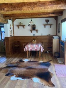 una sala da pranzo con tavolo e un grande tappeto di Chalet nel cuore delle Dolomiti a Falcade