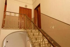 una escalera en una casa con barandilla de madera en Appartamento Centro Storico con balcone e camino - Tarquinia, en Tarquinia