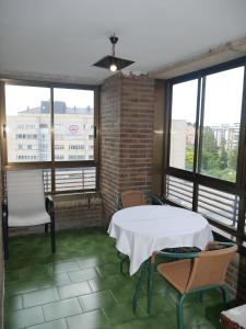a room with a table and chairs and windows at Hostal Meson Del Barro - Alojamientos Pamplona in Pamplona