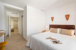 Un dormitorio blanco con una cama grande y un pasillo en Calella Apartments by Olala Homes, en Calella