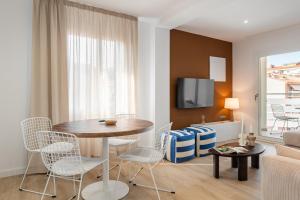 Una sala de estar con una mesa y sillas y un sofá. en Calella Apartments by Olala Homes, en Calella