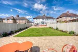 a backyard with a fence and a table and chairs at Viewtopia House in Whittington