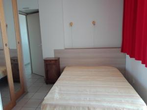 1 dormitorio con cama y cortina roja en Appartement Les Sables-d'Olonne, 2 pièces, 4 personnes - FR-1-331-22 en Les Sables-dʼOlonne