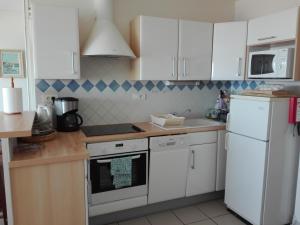 una cocina con armarios blancos y electrodomésticos blancos en Appartement Les Sables-d'Olonne, 2 pièces, 4 personnes - FR-1-331-22 en Les Sables-dʼOlonne