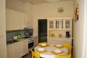 プラハにあるSunflower 2BDR Flat By Ruterraのテーブルと黄色い椅子付きのキッチンが備わります。