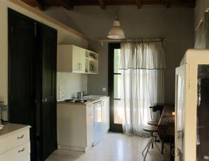 a kitchen with white cabinets and a sink and a refrigerator at Chorto Garden Home in Chorto