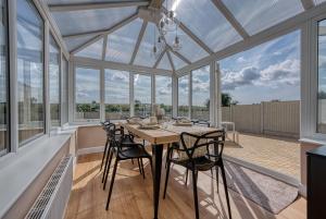 a glass conservatory with a table and chairs at Viewtopia House in Whittington