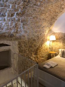 1 dormitorio con 1 cama en una pared de piedra en Cà Giò en Ostuni