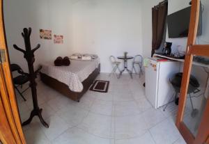 Habitación pequeña con cama y nevera. en Suite Privativa Lar e Aconhego en Maricá