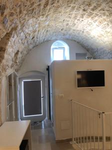 a room with a stone wall and a door with a window at Cà Giò in Ostuni