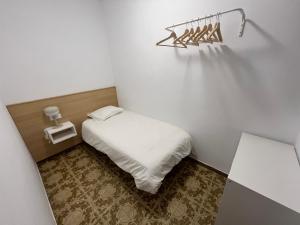 a small white room with a bed and a wall at El Popet de Baix a Mar in Torredembarra
