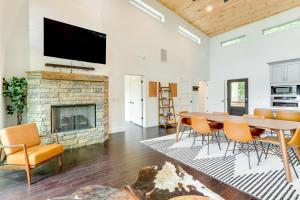 a living room with a table and chairs and a fireplace at Mid-Century Modern Home with Hot Tub and Mtn Views! in Ellijay