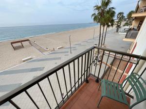 un balcón con un banco y la playa en El Popet de Baix a Mar en Torredembarra