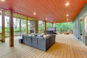a screened porch with a couch and a fireplace at Mid-Century Modern Home with Hot Tub and Mtn Views! in Ellijay
