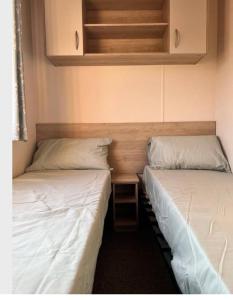 two beds sitting next to each other in a room at 8 berth caravan,pet friendly. in Merston