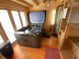 a large tub in a room in a tiny house at Nid du merle avec sauna et jacuzzi privatif in Septfonds