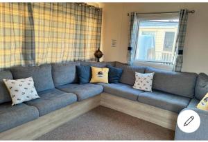 a blue couch with pillows in a living room at 8 berth caravan,pet friendly. in Merston