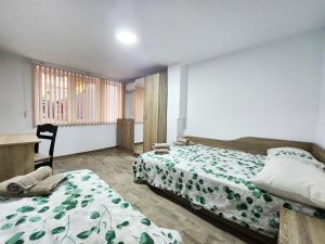 1 dormitorio con 2 camas, escritorio y ventana en Cosy apartment with a sunny balcony in Varna en Varna