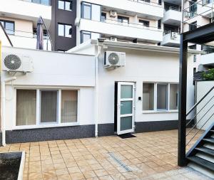 Edificio blanco con puerta y balcón en Cosy apartment with a sunny balcony in Varna en Varna