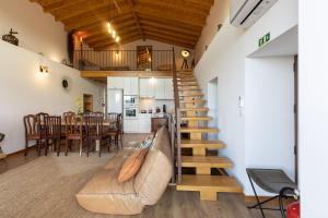 a living room with a couch and a staircase at HUGS Nature Retreat Heated Pool & Jacuzzi in Vila Verde