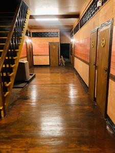 an empty hallway with wooden floors and stairs at โรงแรมคุ้มเดช - KoomDech Hotel in Sattahip
