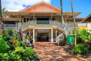 a building on the beach with palm trees at 1Br 1Ba Kahala Tropical Dream, Pool, Garden View 513 in Koloa