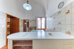 cocina con encimera blanca y reloj en la pared en Casa Maddalena en Diso