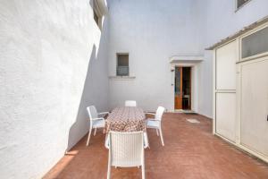 una mesa y sillas en una habitación con una pared blanca en Casa Maddalena en Diso